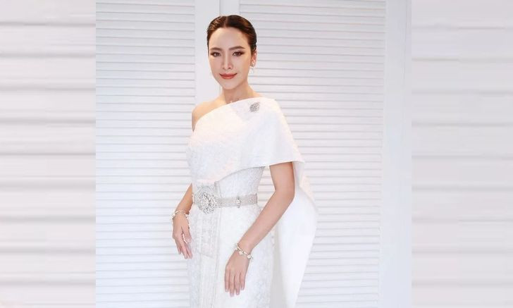 Maprang Wirakarn in a white Chakri outfit with a single shoulder drape and silver belt.