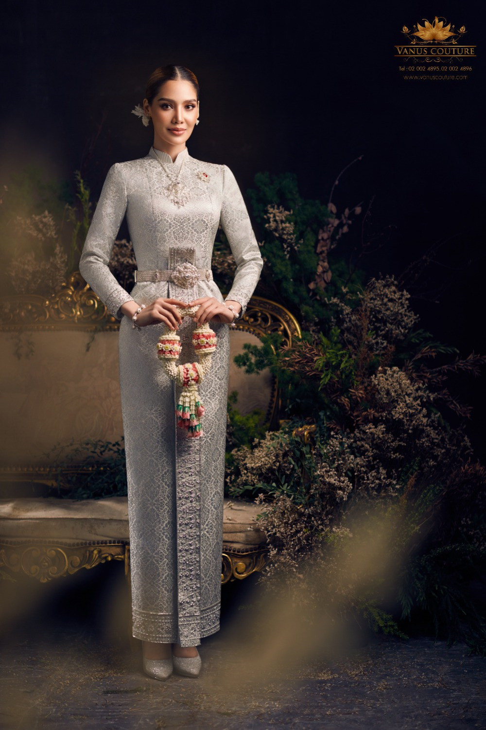 Vanus Couture model in a silver Boromphiman dress with long sleeves, standing collar, belt and no shoulder drape.